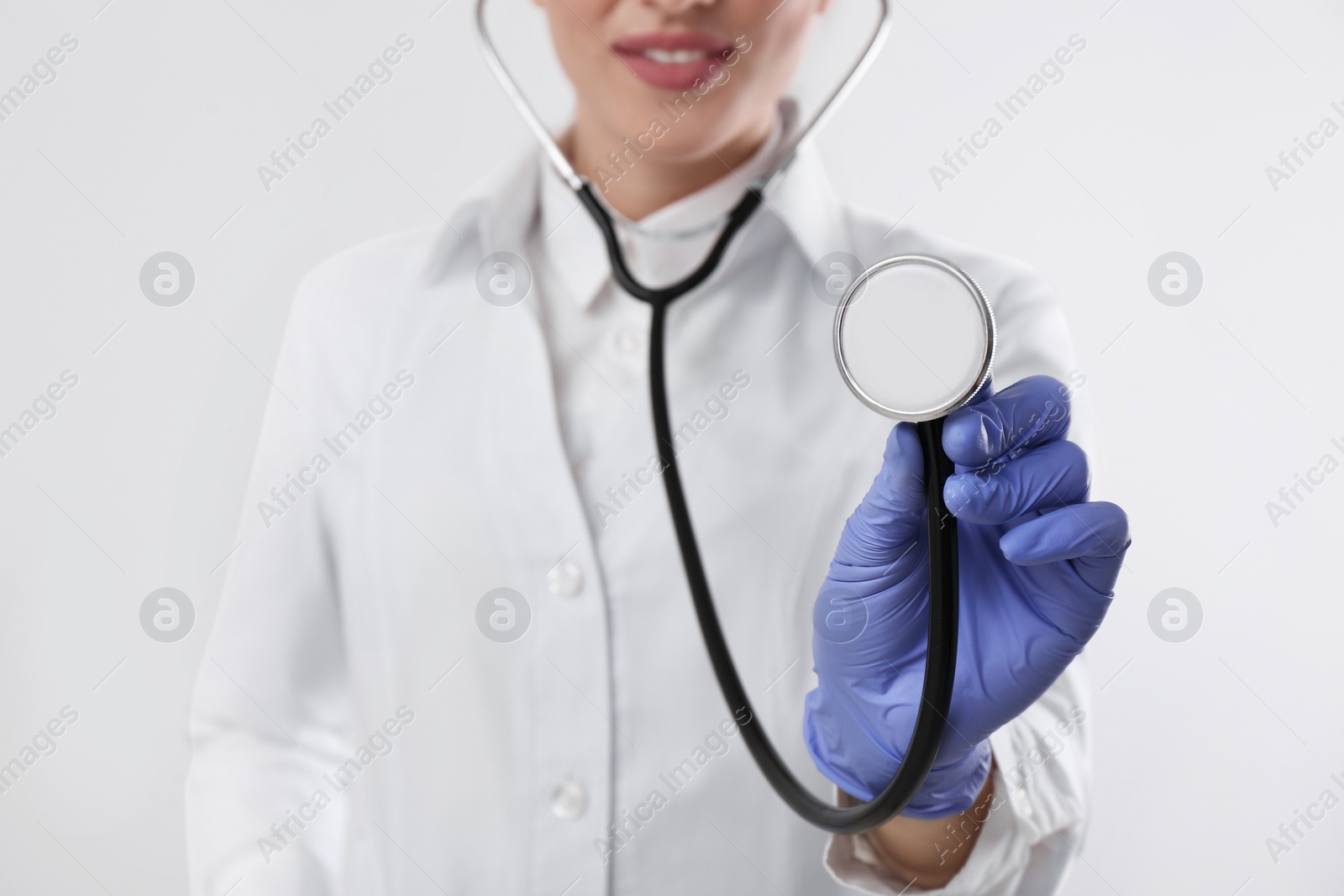 Photo of Doctor with stethoscope on white background, closeup. Cardiology concept