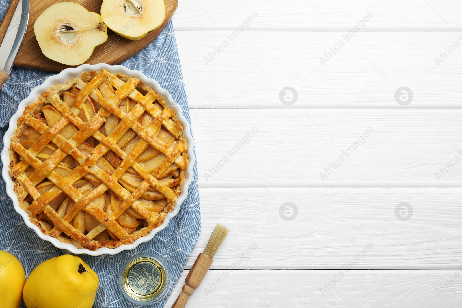 Photo of Tasty homemade quince pie on white wooden table, flat lay. Space for text