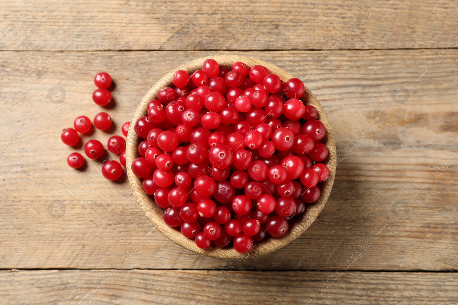 Photo of Ripe fresh cranberry on wooden table, flat lay