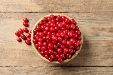 Photo of Ripe fresh cranberry on wooden table, flat lay