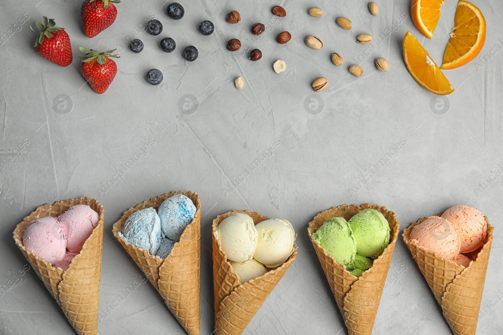 Photo of Flat lay composition with delicious ice creams in waffle cones on table, space for text