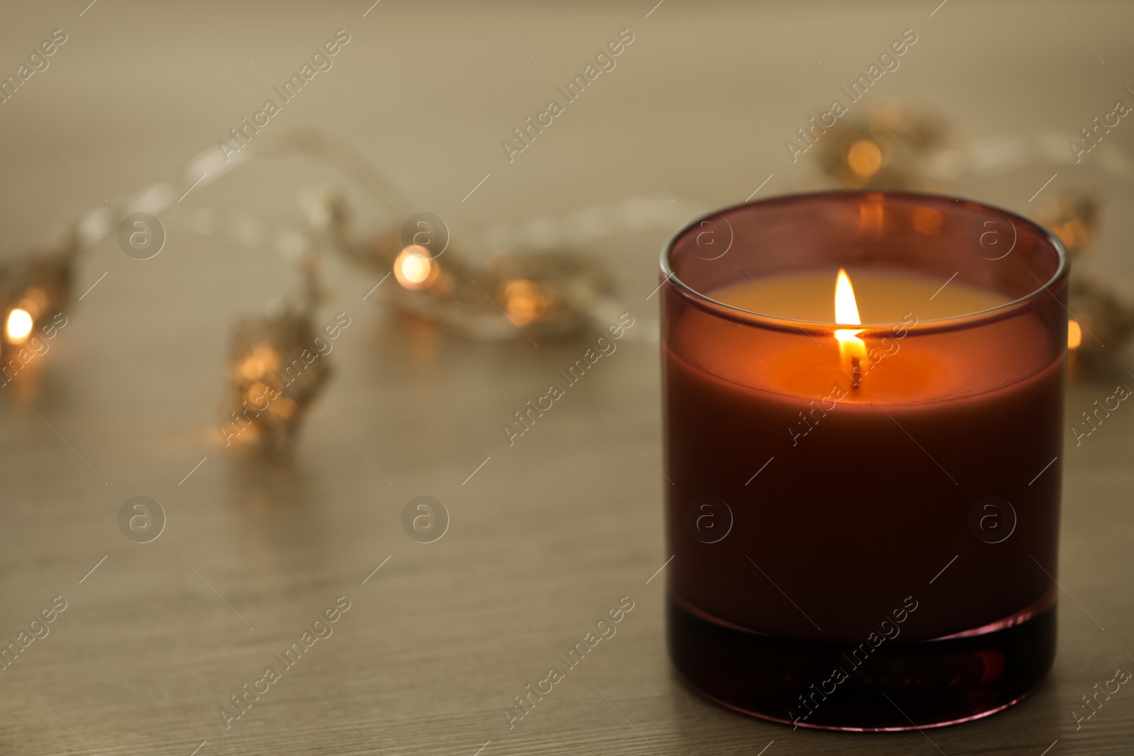 Photo of Burning candle in holder on table, closeup. Space for text