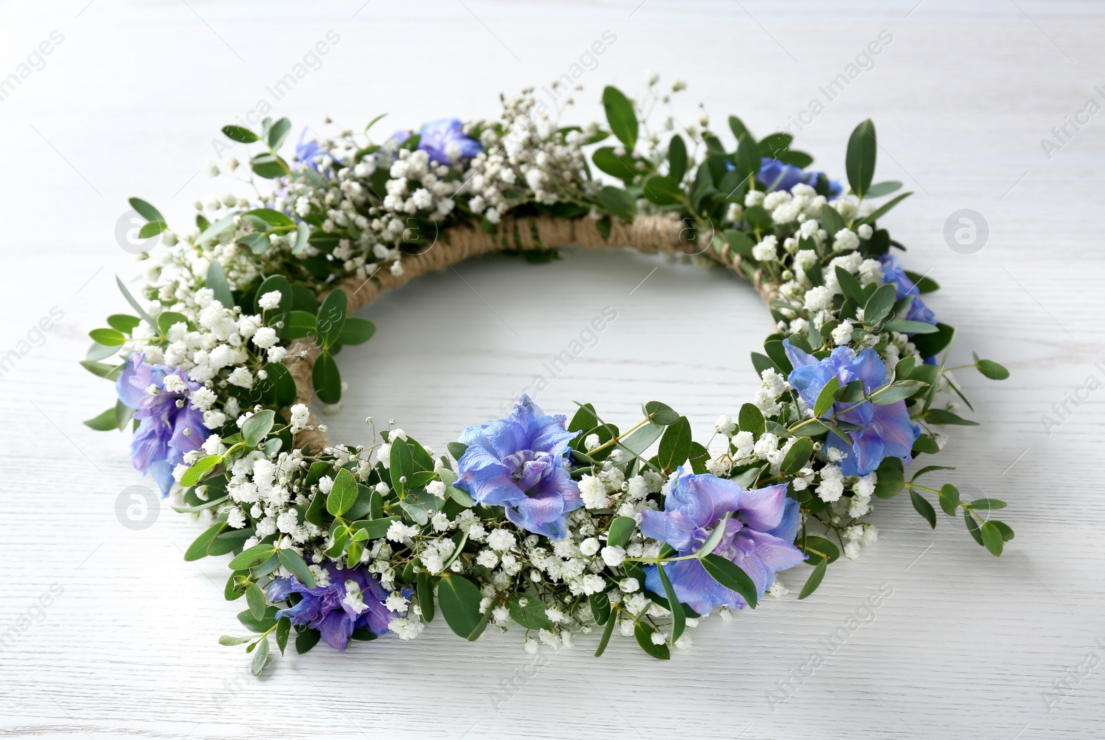 Photo of Beautiful flower wreath on white wooden background