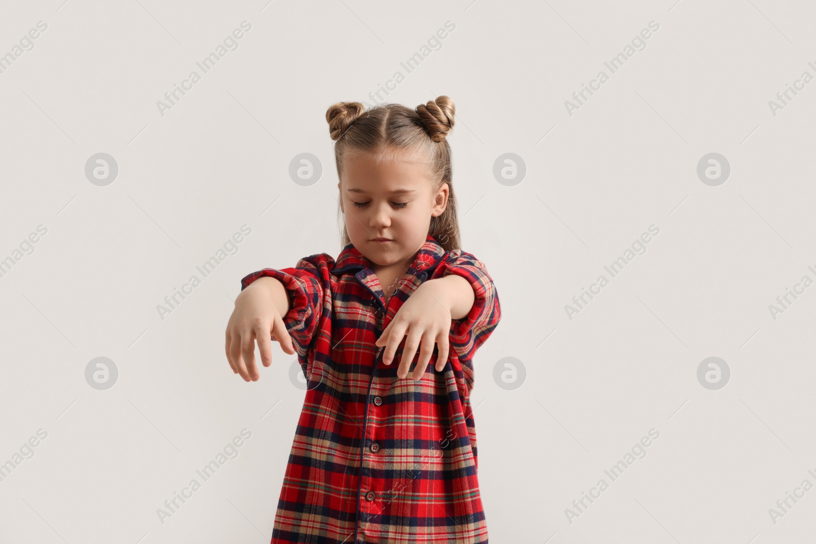 Photo of Girl in pajamas sleepwalking on white background
