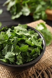 Photo of Cut fresh green cilantro in bowl on table, closeup
