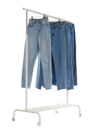 Photo of Rack with different jeans isolated on white