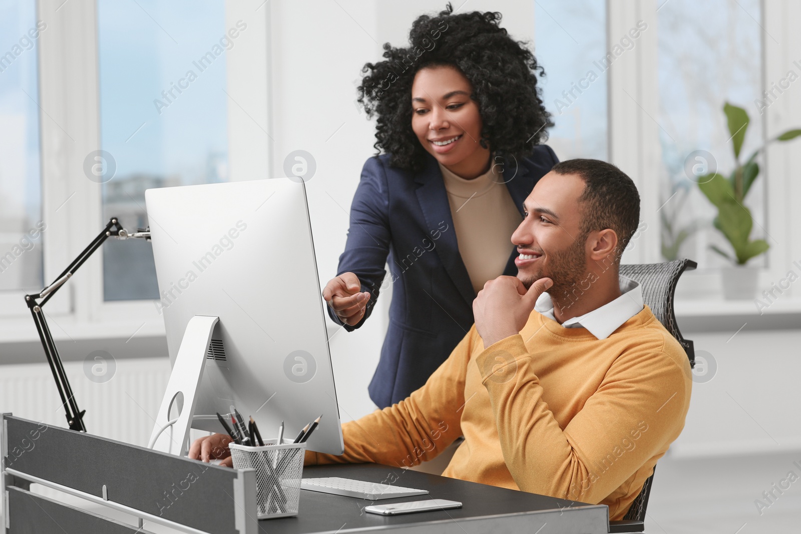 Photo of Young colleagues working together at table in office