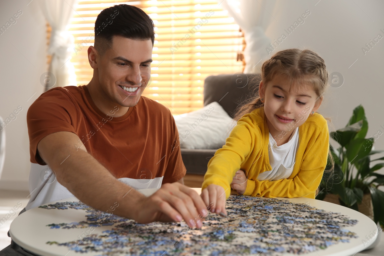 Photo of Happy family playing with puzzles at home