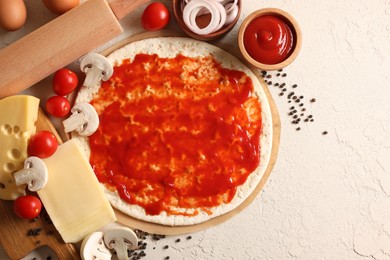 Photo of Pizza base smeared with tomato sauce, peppercorns and products on light textured table, flat lay