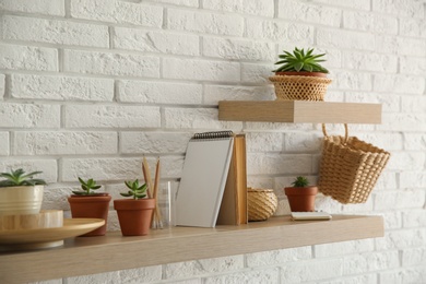 Shelves with decorative elements on white brick wall. Interior design