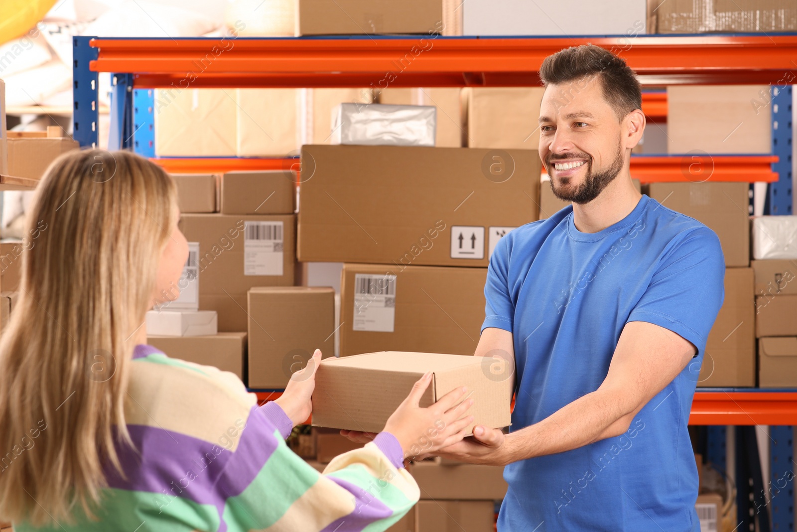 Photo of Worker giving parcel to woman at post office