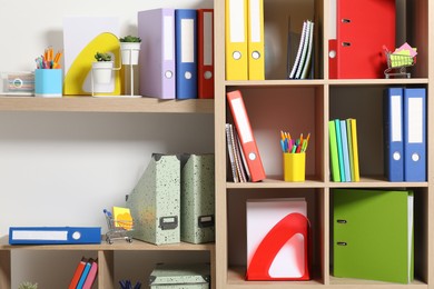 Photo of Colorful binder office folders and other stationery on shelving unit