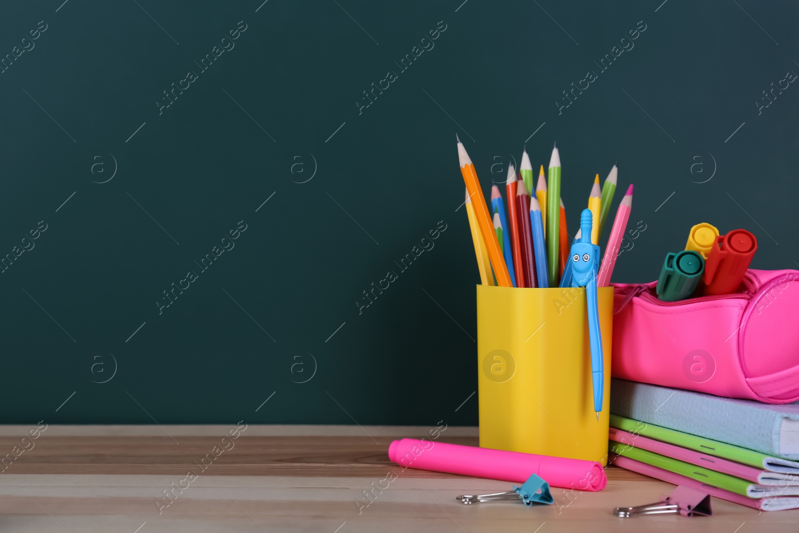 Photo of Stationery on wooden table near chalkboard, space for text. Doing homework