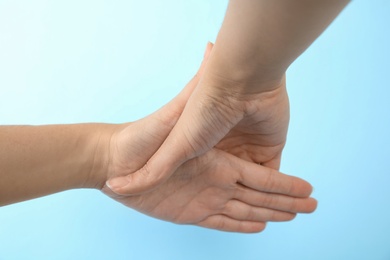 Woman showing hand sign on color background, closeup. Body language