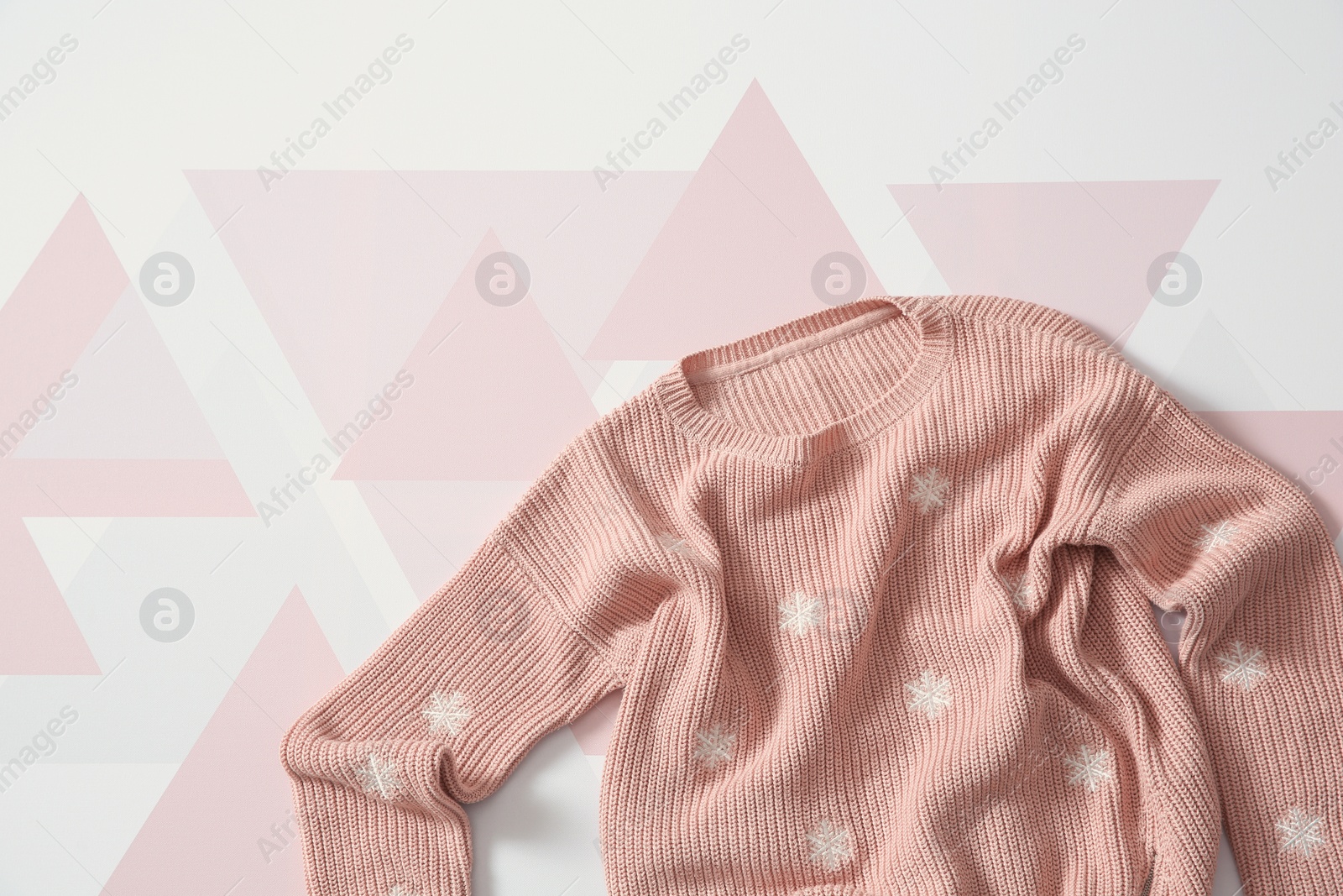 Photo of Top view of cozy knitted sweater on color background. Space for text