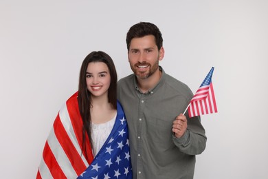 Photo of 4th of July - Independence Day of USA. Happy father and his daughter with American flags on white background