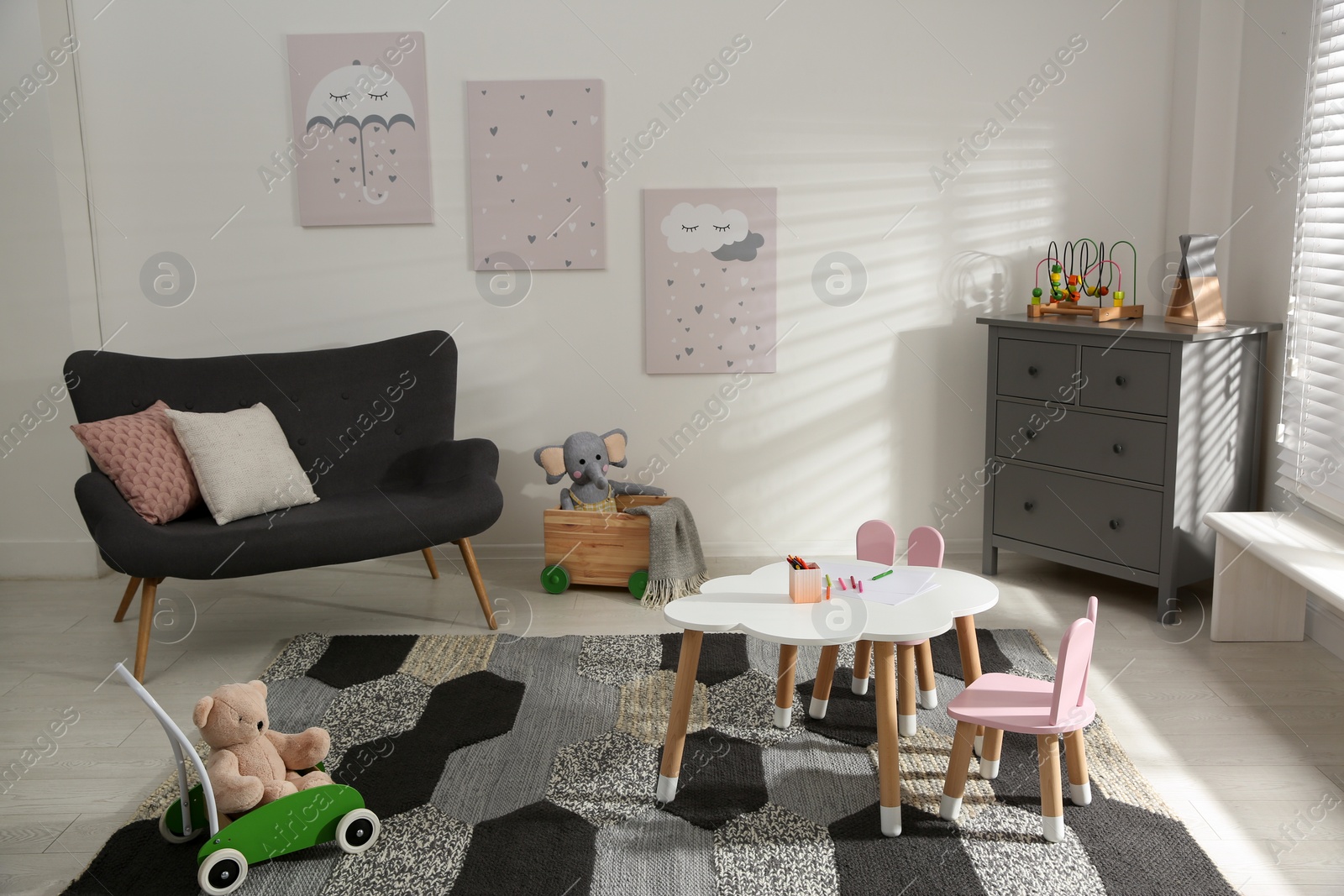 Photo of Cute children's room interior with sofa and little table