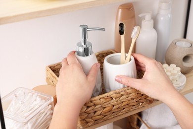 Photo of Bath accessories. Woman organizing personal care products indoors, closeup