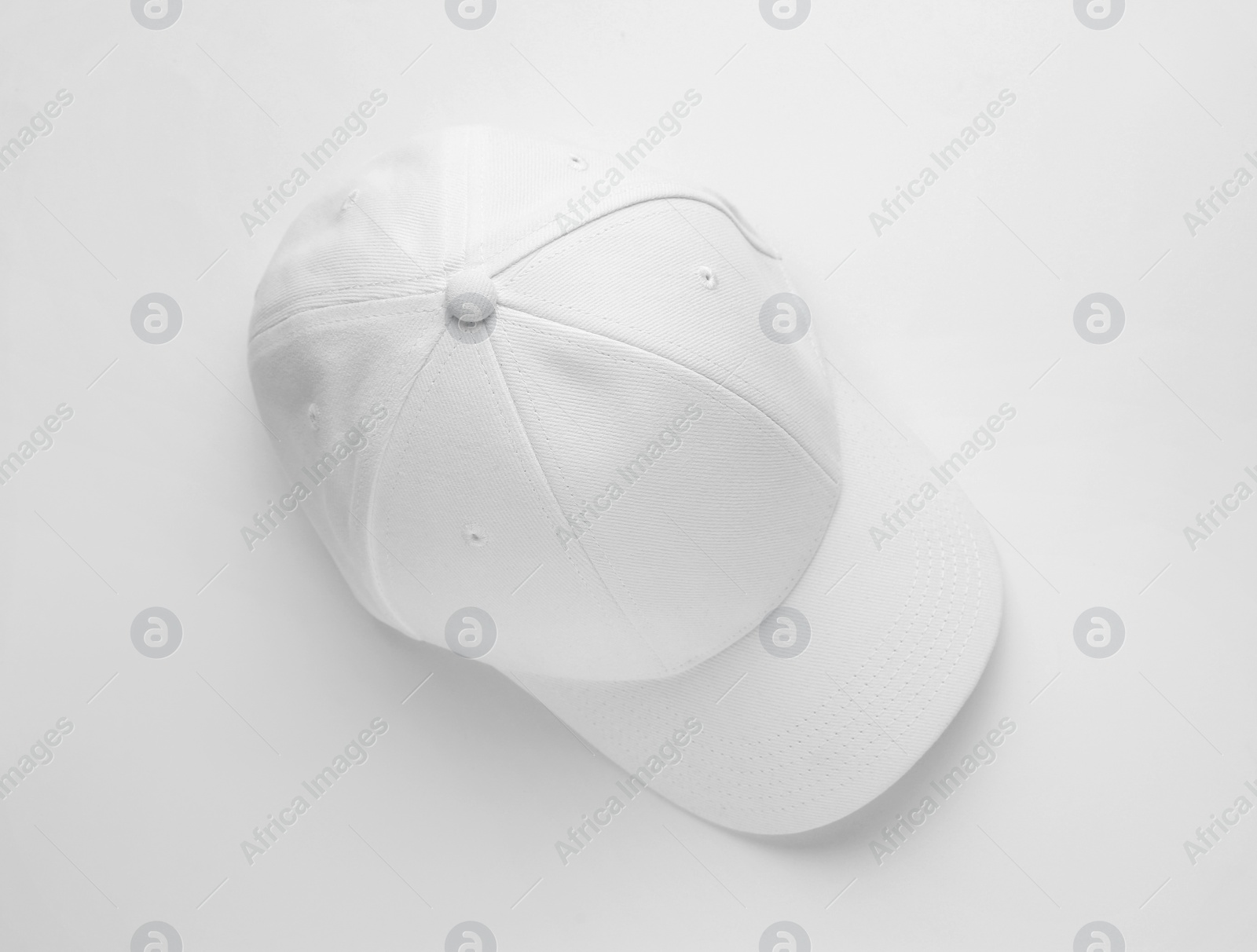 Photo of Stylish baseball cap on white background, top view. Space for text