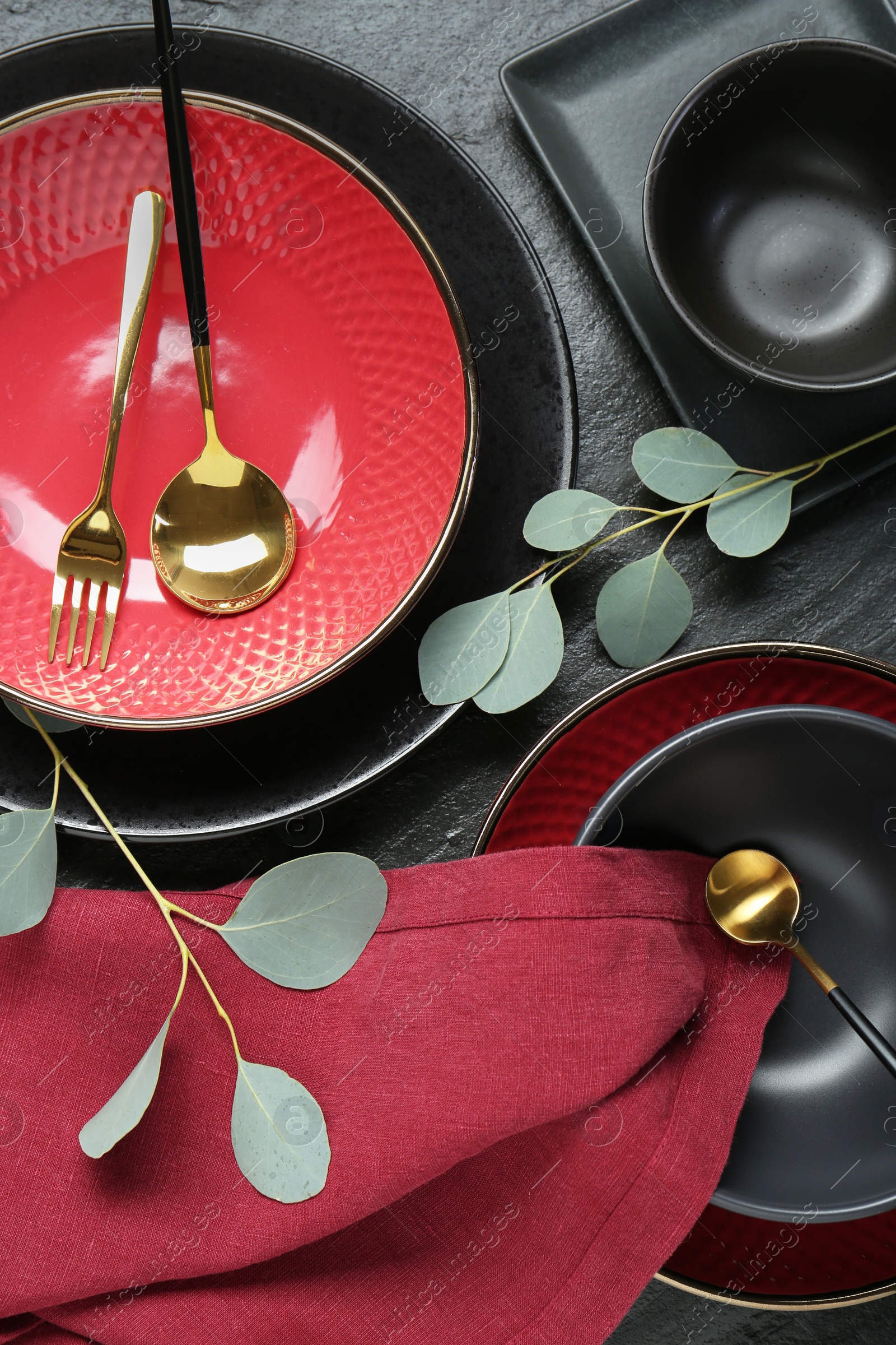 Photo of Flat lay composition with stylish ceramic plates and floral decor on grey table