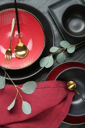 Flat lay composition with stylish ceramic plates and floral decor on grey table