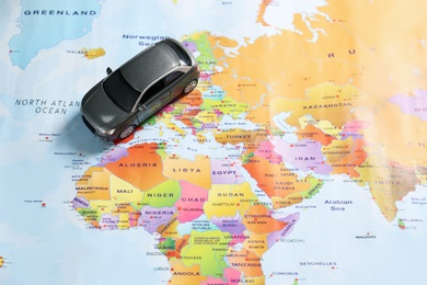 Photo of Grey toy car on world map. Trip planning
