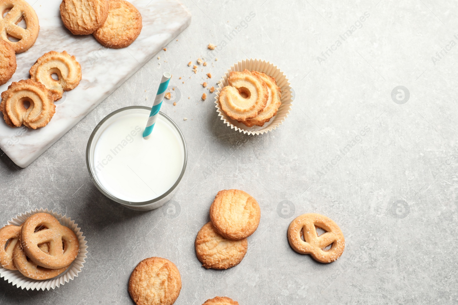 Photo of Flat lay composition with Danish butter cookies and glass of milk on grey background, space for text