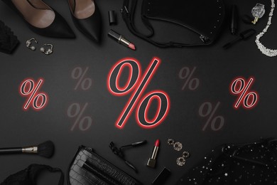 Image of Discount offer. Women's clothes, makeup products, accessories and percent signs on black background, flat lay