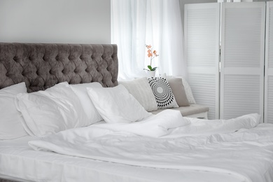 Photo of Bed with soft pillows in elegant room interior