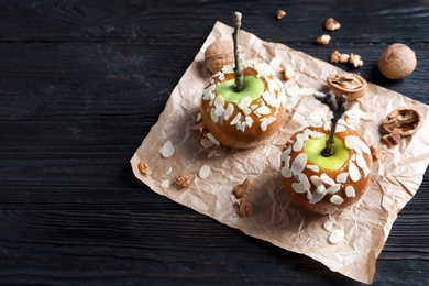 Photo of Delicious caramel apples on wooden background