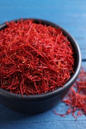 Photo of Dried saffron on blue wooden table, closeup