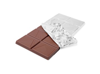 Photo of Delicious milk chocolate bar wrapped in foil isolated on white