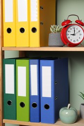 Colorful binder office folders and other stationery on shelving unit