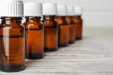 Photo of Glass bottles with essential oil on wooden table