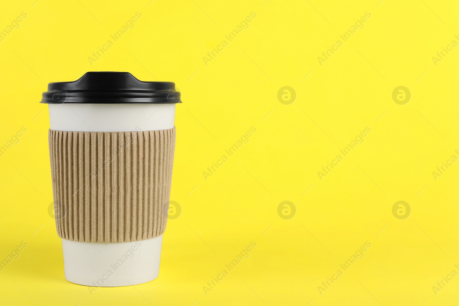 Photo of Paper cup with plastic lid on yellow background, space for text. Coffee to go