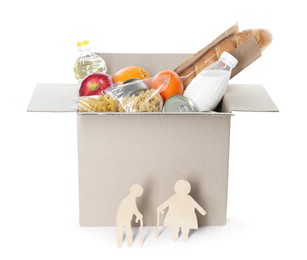 Photo of Humanitarian aid for elderly people. Cardboard box with donation food and wooden figures of couple isolated on white