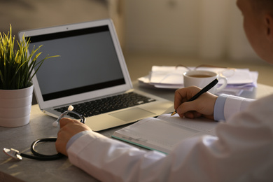 Professional doctor working at table in office, closeup