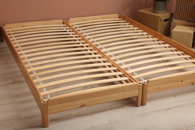 Photo of Wooden bed frame and cardboard boxes on floor in room