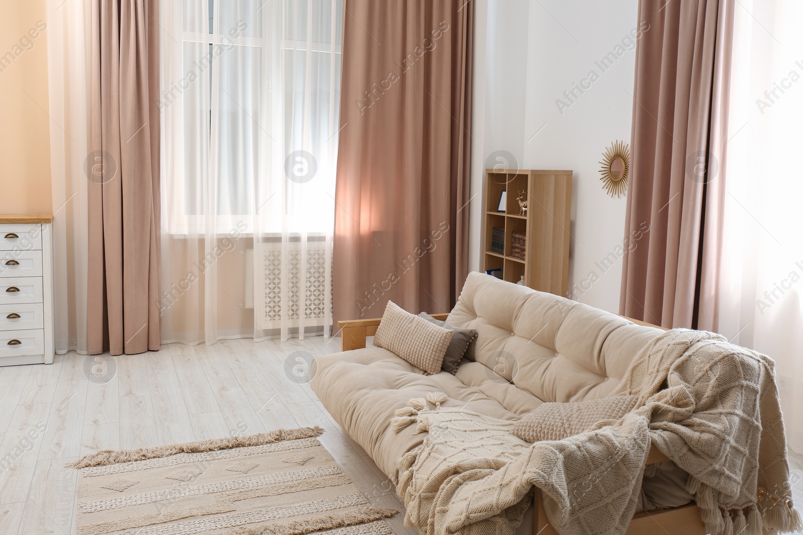 Photo of Comfortable sofa with cushions and blanket in cozy room. Interior design
