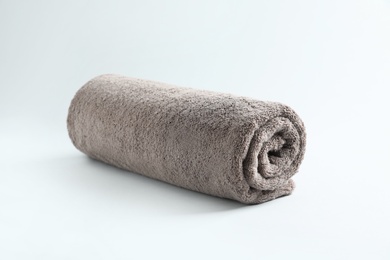 Photo of Fresh fluffy rolled towel on grey background