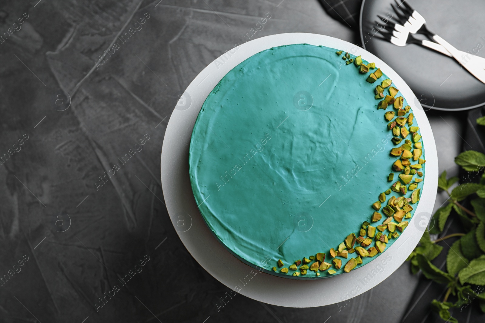 Photo of Delicious homemade spirulina cheesecake served on black table, top view