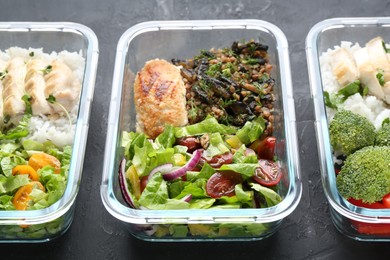 Photo of Healthy food. Different meals in glass containers on black table