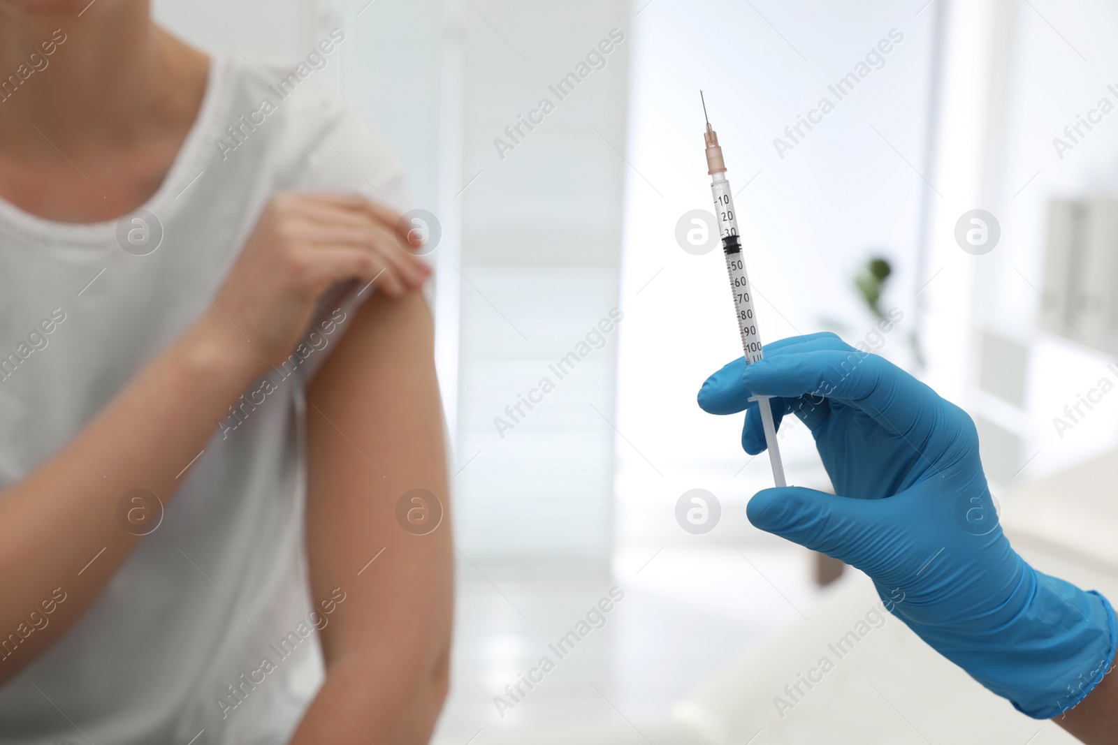 Photo of Doctor giving injection to woman in hospital, closeup. Immunization concept