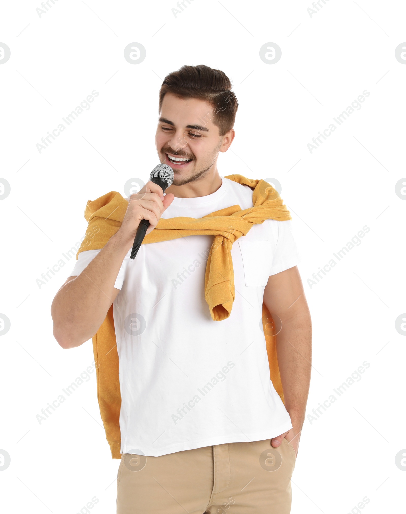 Photo of Young handsome man in casual clothes posing with microphone on white background