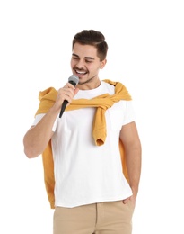 Photo of Young handsome man in casual clothes posing with microphone on white background