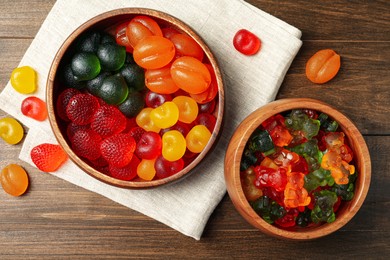 Delicious gummy candies on wooden table, flat lay