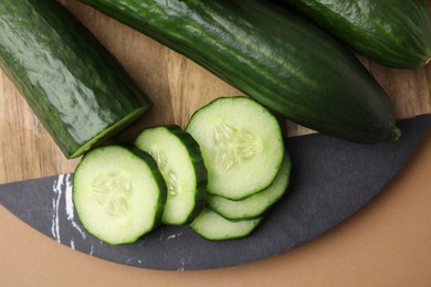 Photo of Fresh cucumbers on beige background, top view