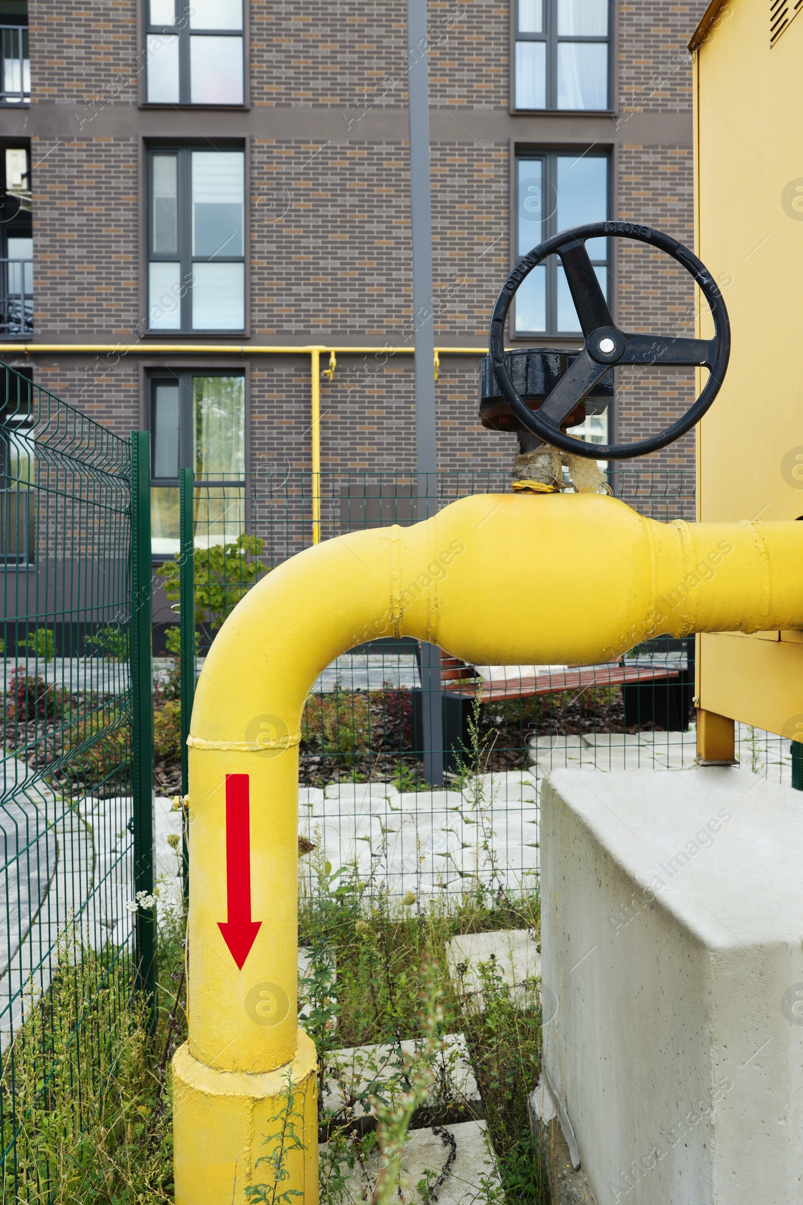 Photo of Black flywheel on yellow gas pipe outdoors