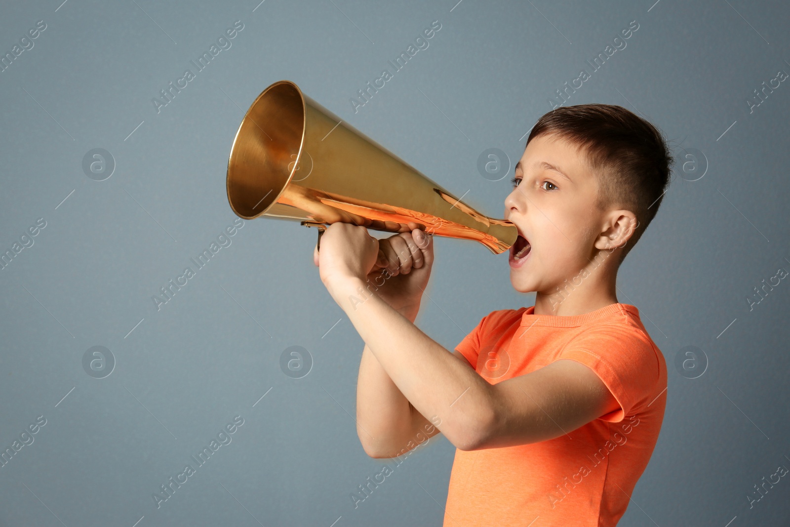Photo of Cute little boy with megaphone on grey background