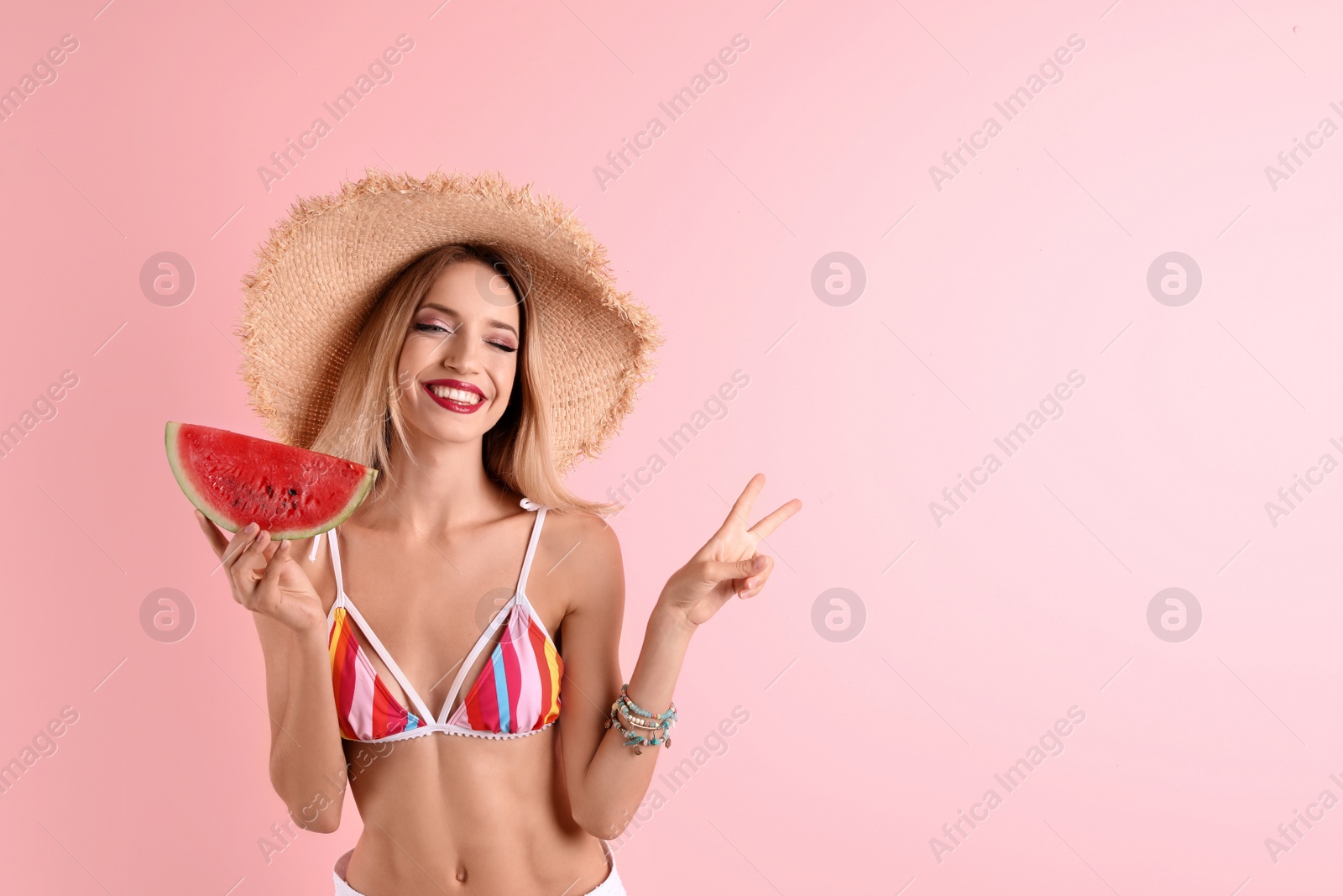 Photo of Pretty young woman with juicy watermelon on color background